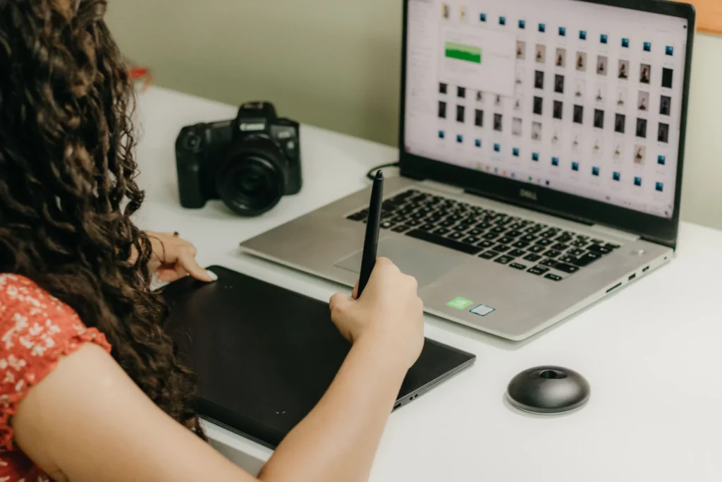 Photographe professionnel retouchant des photos sur ordinateur portable, illustrant le retour sur investissement d'un shooting professionnel